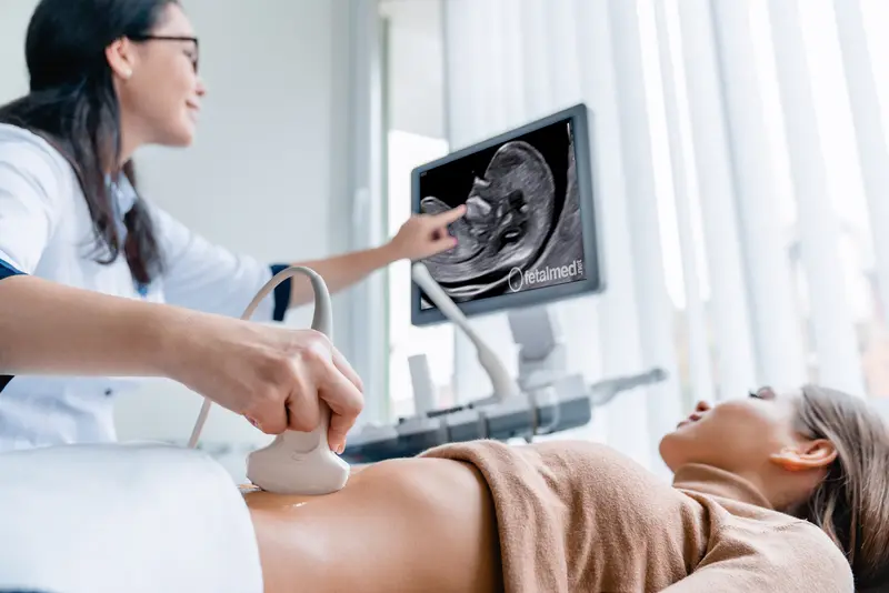 Gestante realizando exame de translucência nucal por via abdominal no primeiro trimestre
