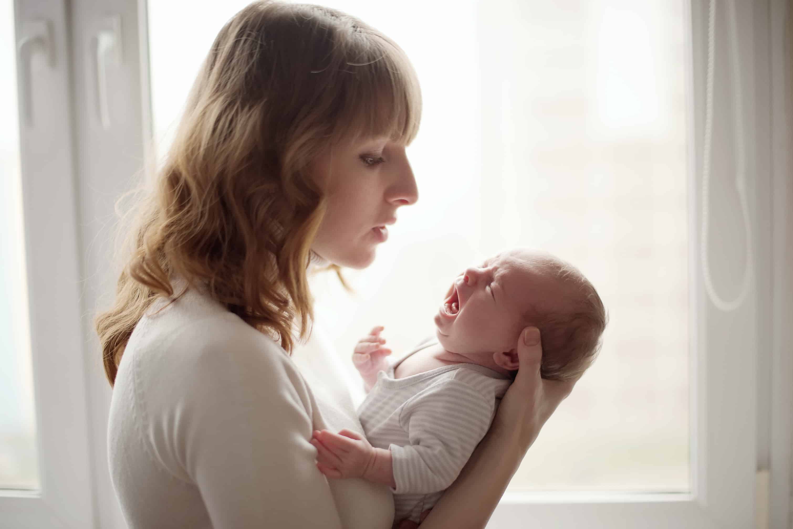 Mãe cuidando do bebê com choro